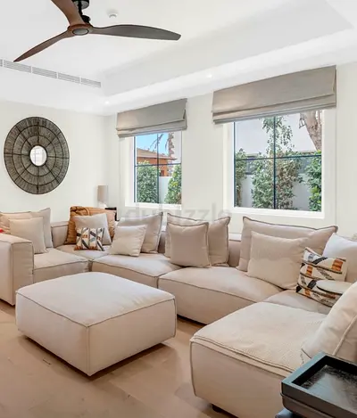 Large beige sectional sofa with ottoman — comfortable family lounge set