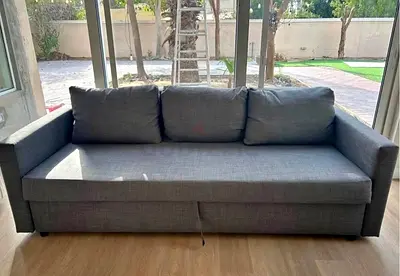 Three-seater grey fabric sofa bed with storage, good condition