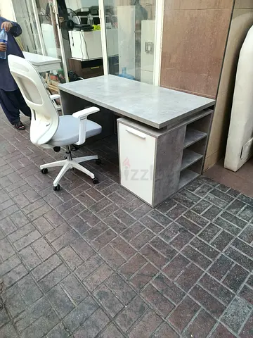 Used concrete-look office desk with storage shelves and drawer