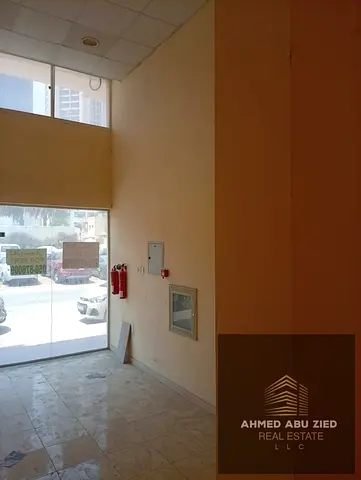 Large commercial shop on a main road directly opposite Grand Mall Ajman. Prime location suitable for various businesses, AED 25,000/year in 4 or 6 ins