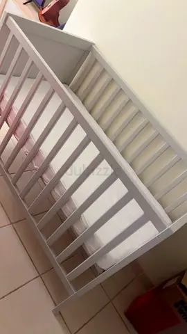 White wooden baby crib in good condition with mattress and cover