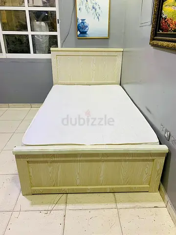 Single wooden bed frame with mattress — light wood finish