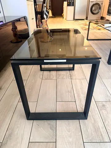 Glass top coffee table with black metal frame