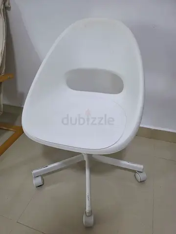 White adjustable swivel office chair on wheels and table