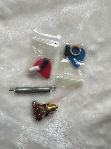 Spare guitar tremolo spring, strap pin and pickup switch — small accessories