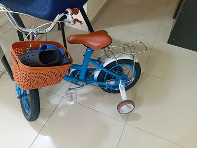 Blue kids' bicycle with training wheels and front basket -need service