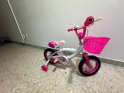 Kids pink & white bicycle with training wheels and front basket