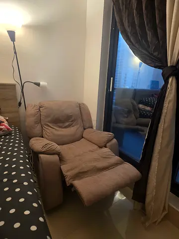 Beige single reclining armchair in good condition