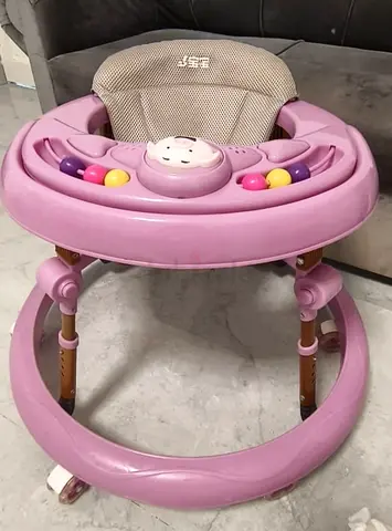 Used pink baby walker with activity tray and adjustable height