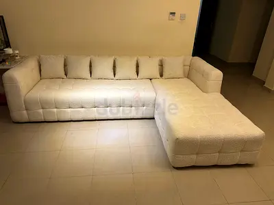 L-shaped white tufted sectional sofa with chaise