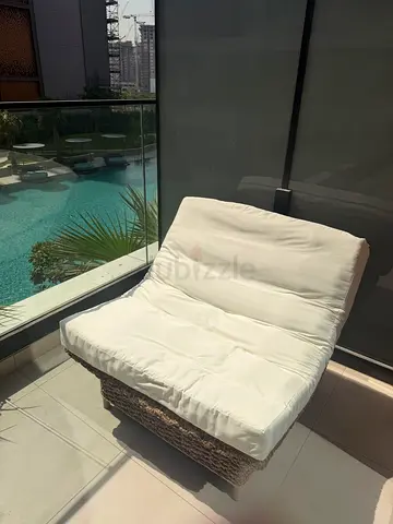 Outdoor wicker lounge chair with white cushion