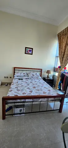 Wooden double bed frame with metal accents — good condition