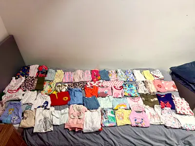 A bundle of baby girl clothes.