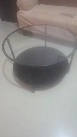 Round glass top coffee table with black metal & brown wooden base