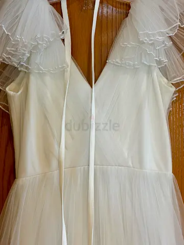 White tulle designer bridal dress with layered ruffle skirt, V-neck and cap sleeves
