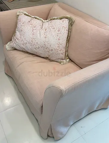 Light pink over sized single-seater armchair with decorative cushion. Heavy high quality