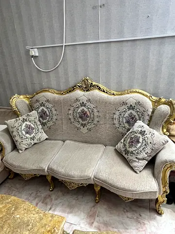 Ornate 3-seater sofa with gold carved frame and patterned cushions