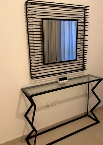 Modern black metal console table with glass top and matching wall mirror