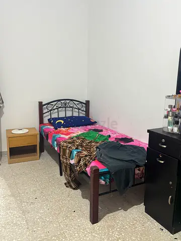 Single metal frame bed with mattress and bedside table