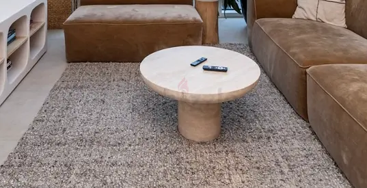 Round travertine coffee table with low pedestal base — good condition
