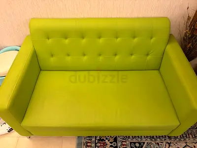 Green two-seater sofa in good used condition