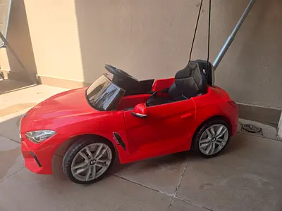 Red electric ride-on BMW-style kids car with parent handle