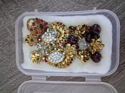 Pair of traditional gold-tone chandelier earrings with red-green stones and pearls and a ring