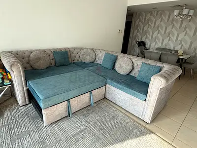 L-shaped tufted fabric sofa with pull-out bed — good condition