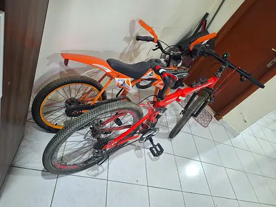 Two kids/teen bikes — red and orange, good working condition