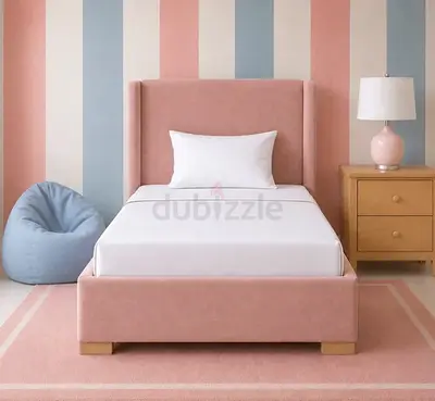 Pink upholstered single bed with padded headboard