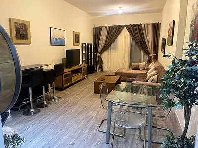 Furnished one-bedroom apartment with a living room for monthly rent in Ajman – Al Rashidiya – Ajman One Towers | Bills and internet included.