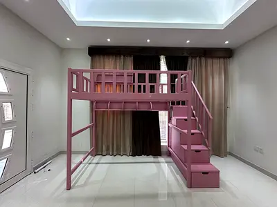 Pink wooden loft bed with staircase and built-in storage