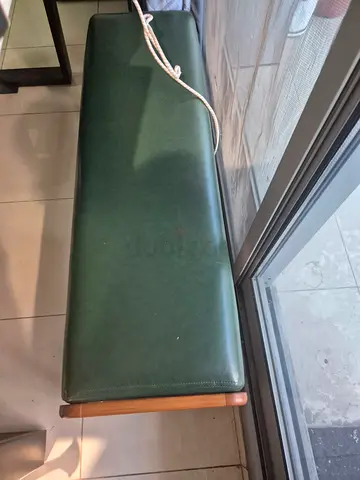 Green leather-upholstered wooden bench — good condition