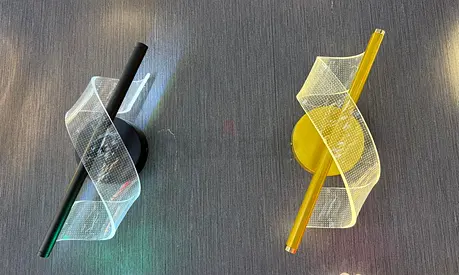 Pair of modern twisted ribbon wall lights — black and yellow bases