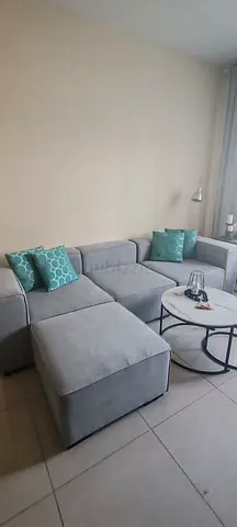 Light grey modular corner sofa with ottoman — good condition
