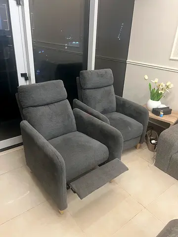 Pair of grey upholstered reclining armchairs with footstool