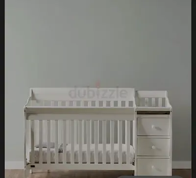 White convertible baby crib with attached changing drawers