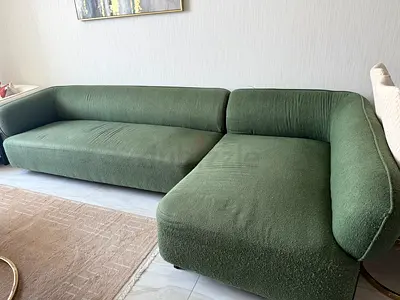 Green upholstered L shaped 5+1 seater sofa in good condition with 5 cushions 50*50 cms