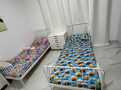 Pair of white metal toddler beds with mattresses — good condition