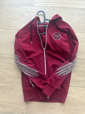 Maroon zip-up hoodie with wing embroidery, size approx M
