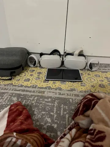 Two Meta Quest 2 (or similar) VR headsets with controllers - used set