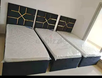 Three single beds with mattresses and modern headboards