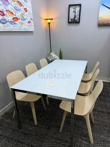 Modern white glass dining table with 6 beige chairs