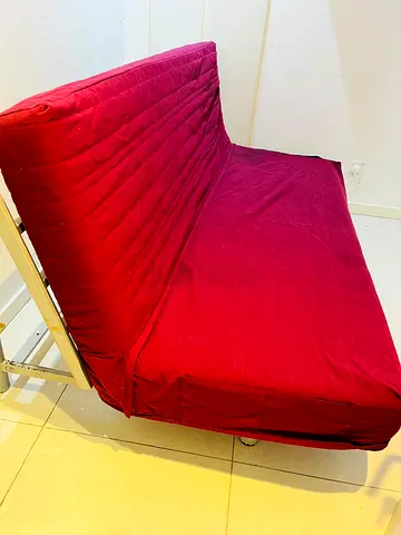 Red upholstered sofa bed / futon - good condition