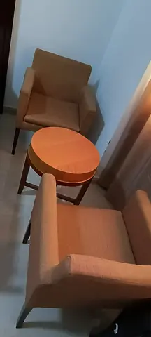 Pair of beige lounge chairs with round side table