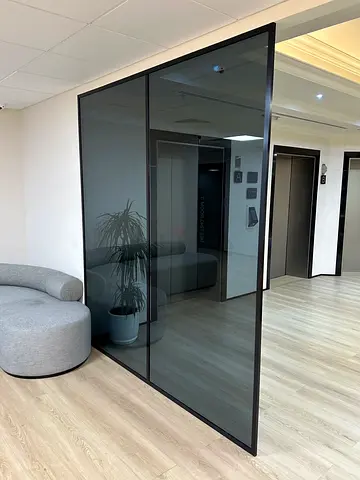 Glass room divider panel with black frame - modern office partition