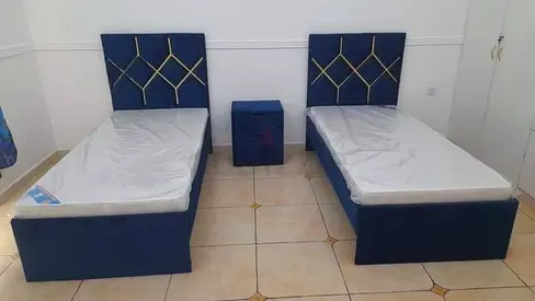 Pair of blue single beds with storage and matching bedside table