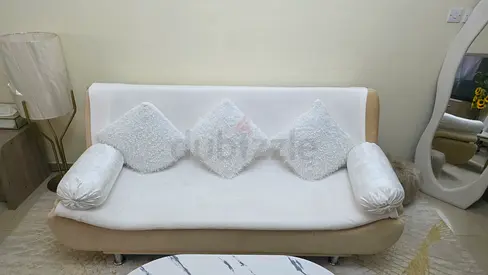 Light beige 3-seater sofa cum bed with white covers and cushions