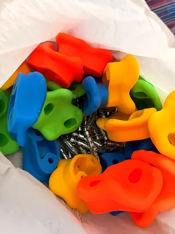 Set of colorful indoor climbing holds with screws — completely new