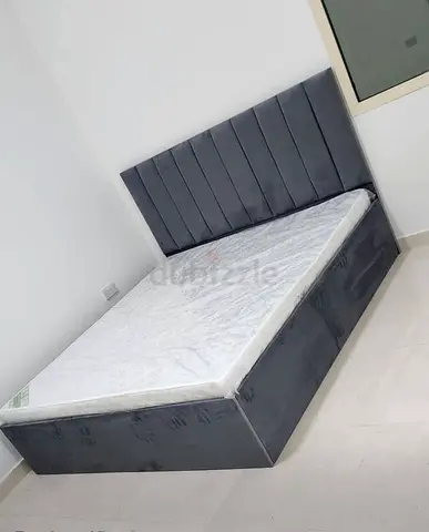 Grey upholstered queen bed with storage — good condition